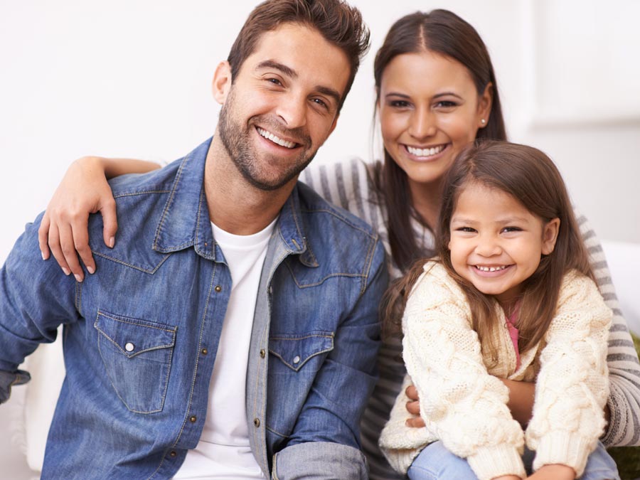 smiling family of three